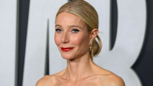 Gwyneth Paltrow wears a strapless dress and low bun hairstyle.